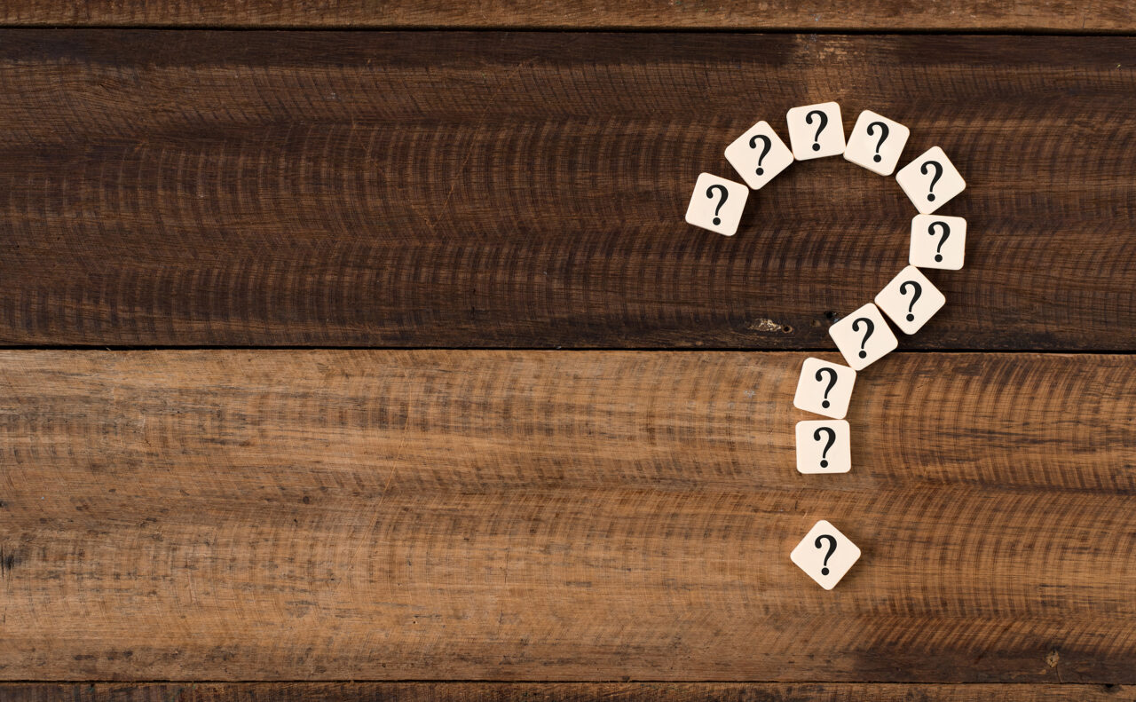 Question mark against a timber background