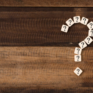 Question mark against a timber background