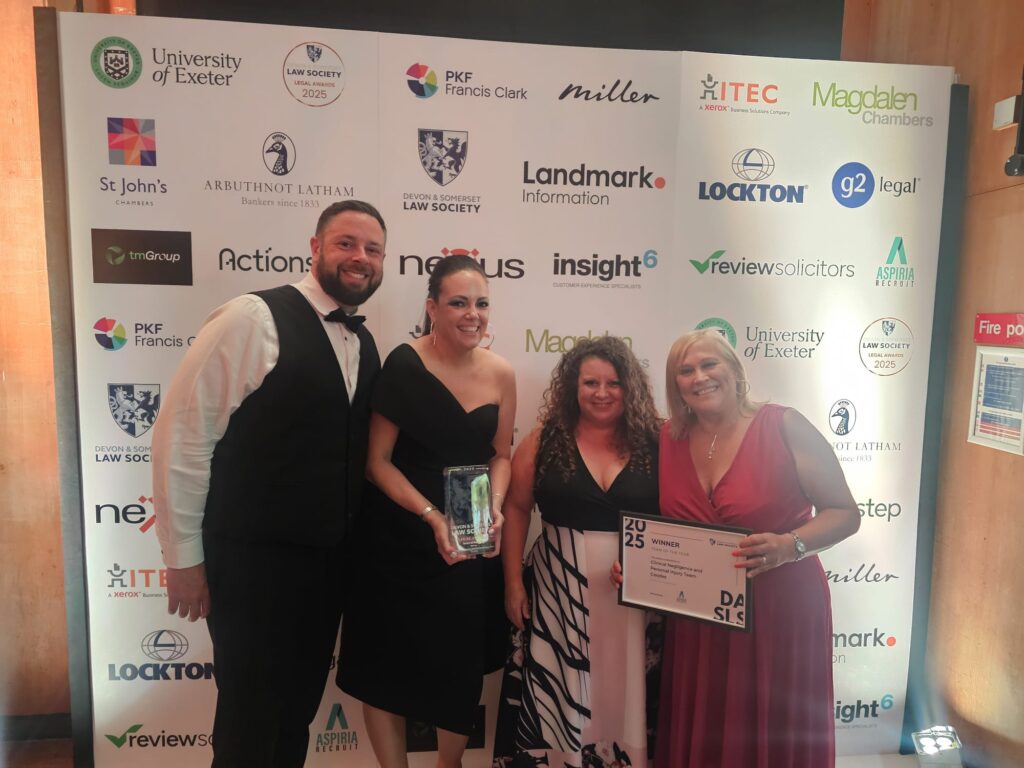 Members of Coodes' Clinical Negligence and Personal Injury teams holding their awards and smiling. 